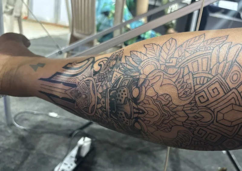 Close-up of Ravi's arm tattoo with Aztec linework